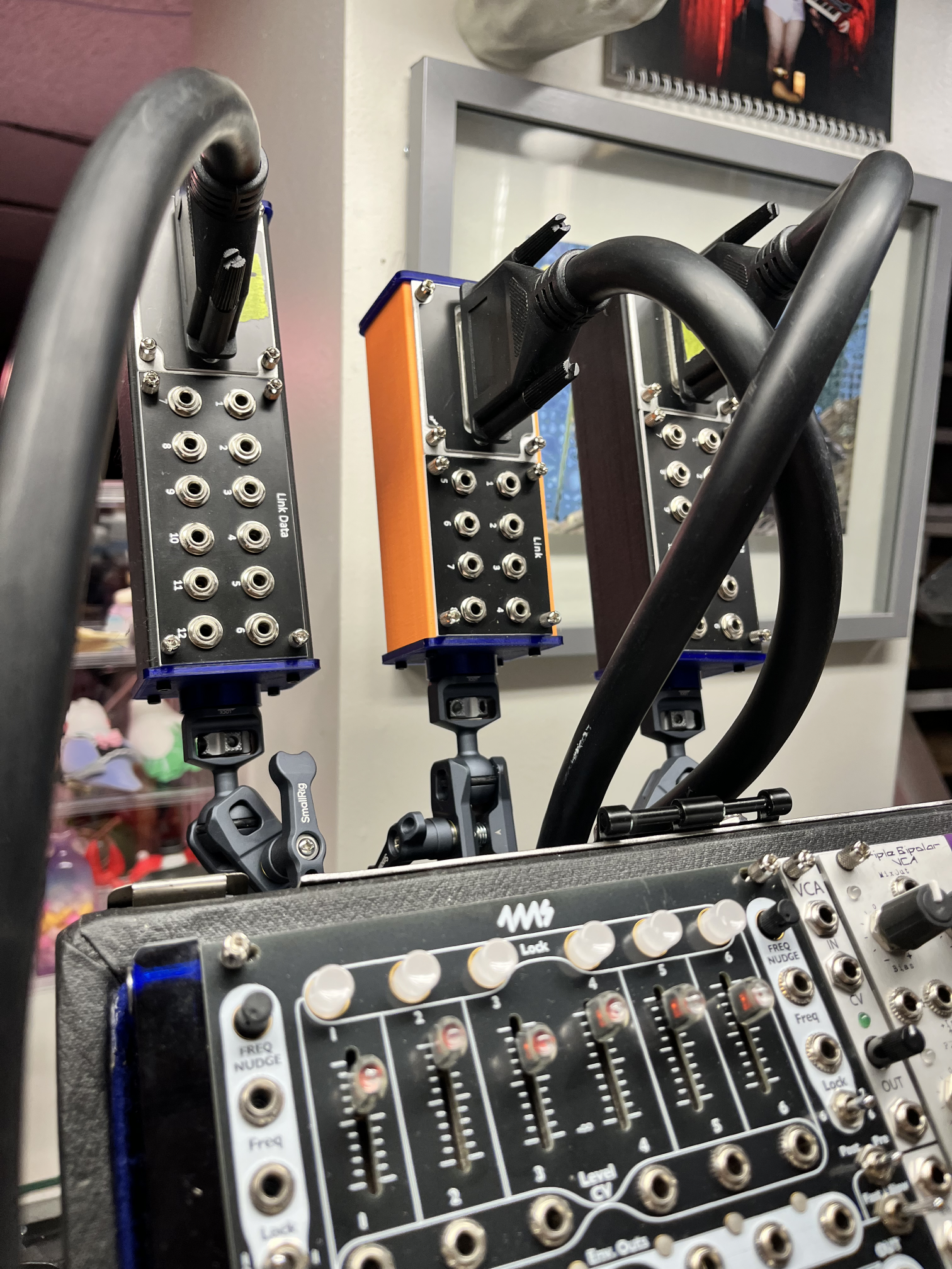 Three Smallrig Magic Arm Ball Joint holding three PulpLogic 1u Tile cases upright behind my Eurorack modular synthesizer.